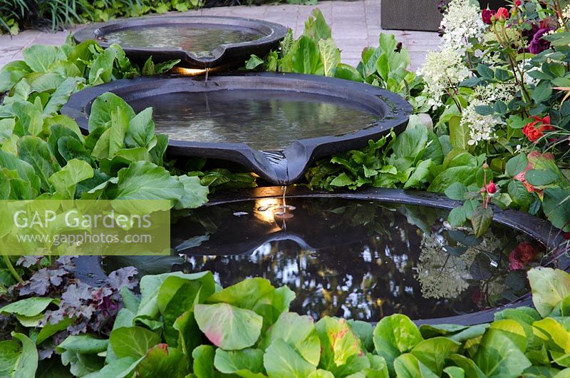 3 tiered circular pools with lighting, surrounded by Bergenia - Bacchus Garden, RHS Hampton Court Palace Flower Show 2014 - Design: Wardrop Designs