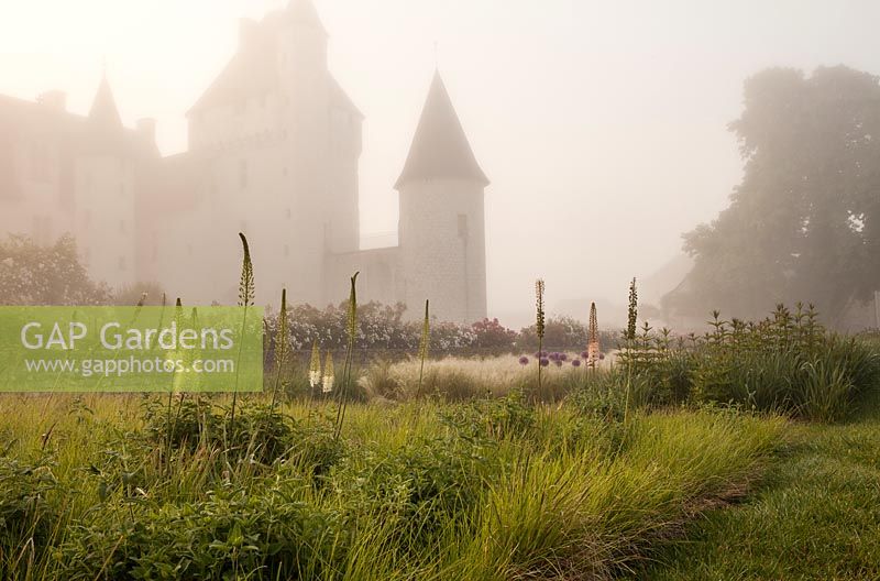 Le Chateau du Rivau in early morning light with Foxtail lilies