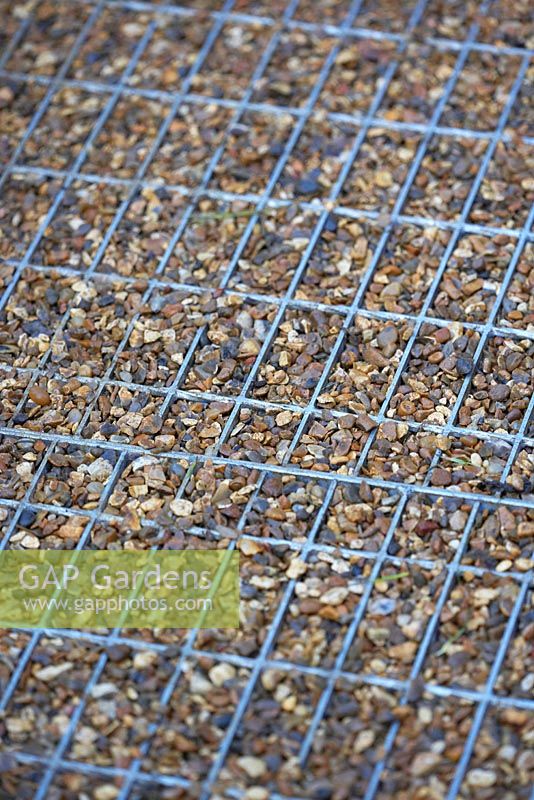 Metal grate on ground with gravel in-fill acting as pathway - A Space to Grow and Connect.  Designers: Jeni Cairns (Juniper House Garden Design) and Sophie Antonelli (Land Girl).  Sponsors: Metal, Earls Scaffolding,British Sugar