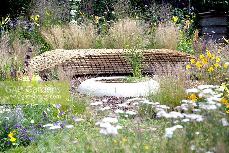 Silver. Best Show Garden. Jordans Wildlife Garden. Design: Selina Botham. Benches of straw bales near pool.