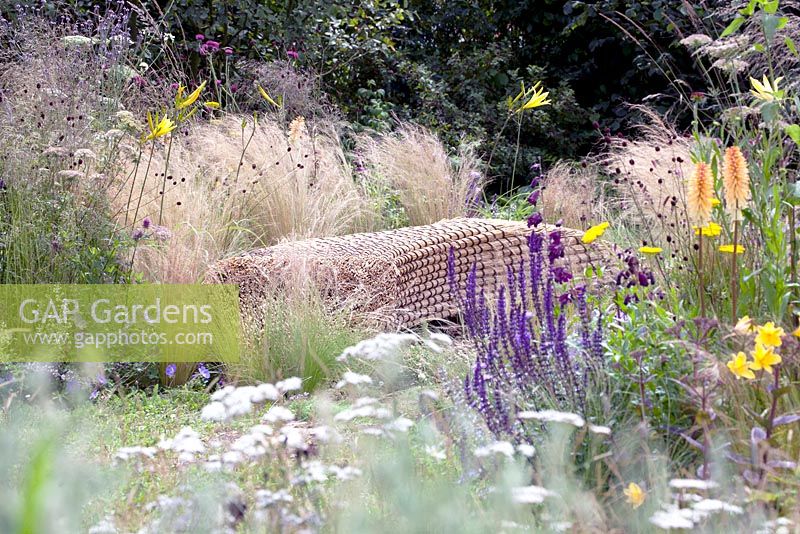 Benches of staw bales near pool - Jordans Wildlife Garden. Design: Selina Botham - Silver. Best Show Garden. RHS Hampton court  flower show 2014