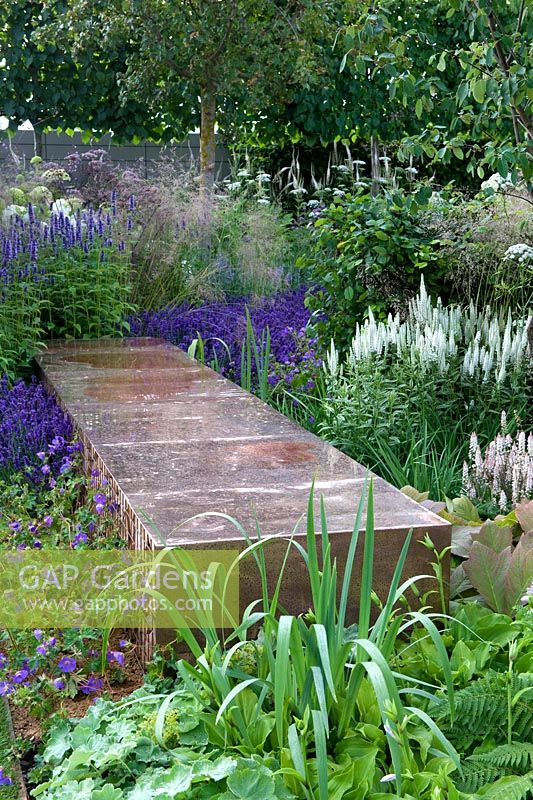 Vestra Wealth's Vista Garden. A copper bench is set in planting or perennials with cool colour palette. Designer: Paul Martin Sponsor: Vestra Wealth Gold award  