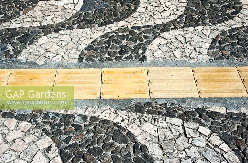 A tactile pathway for the blind leads somewhat clumsily through a Portuguese pavement - design in Salvador in Brazil. 
