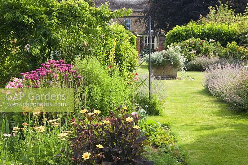 The Sundial Garden. Mixed herbaceous perennials, annuals and dahlias. Hall Farm Garden at Harpswell near Gainsborough in Lincolnshire. July 2014.