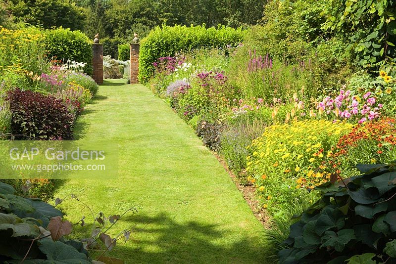 The double herbaceous borders looking from the house. Hall Farm Garden at Harpswell near Gainsborough in Lincolnshire. July 2014.