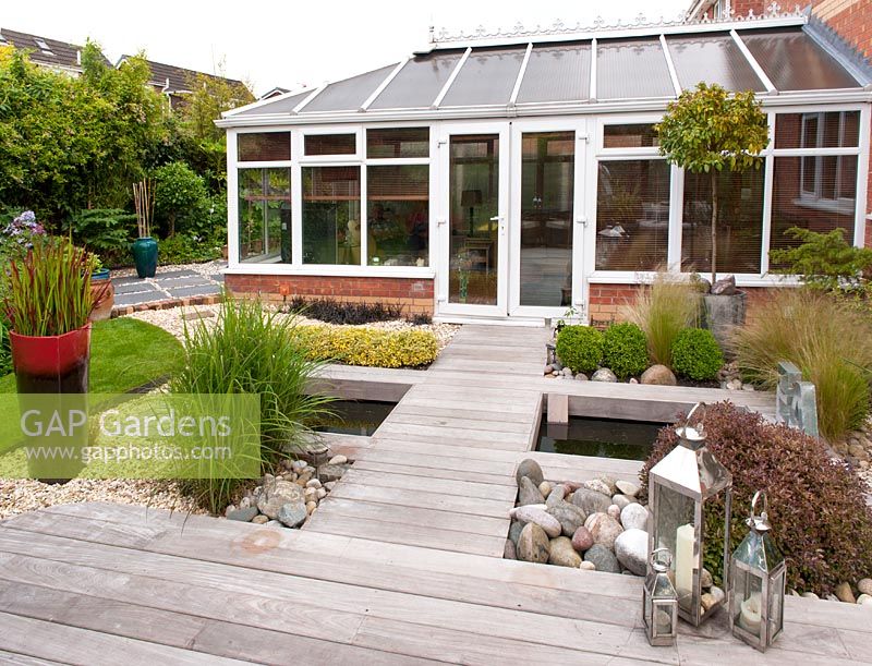 Contemporary Ipe hardwood deck built over pond with conservatory - Acreswood