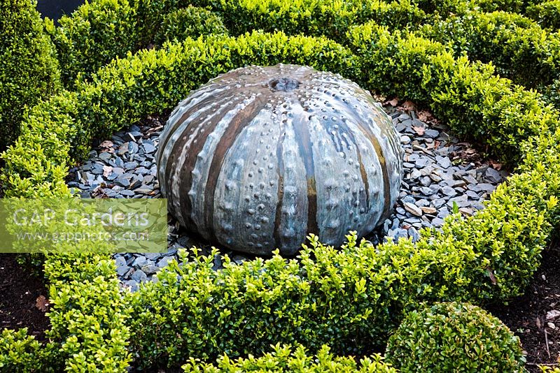 Decroative Sea Urchin Water Feature in a Box parterre with slate stones and gravel