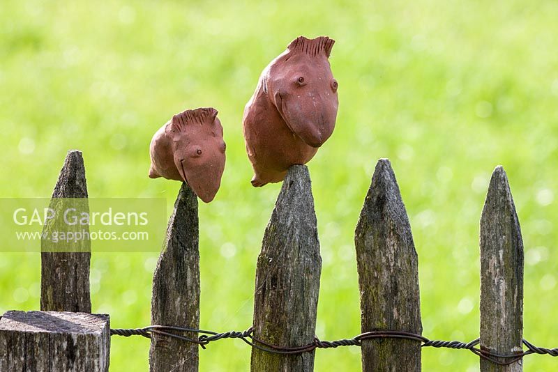 Clay figures topping wooden picket fence