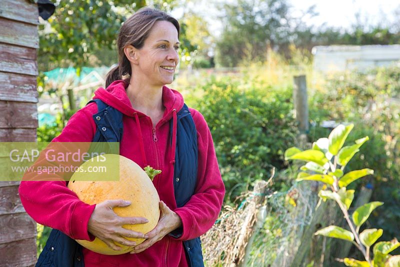 Woman holding harvested Pumpkin Hundred Weight.