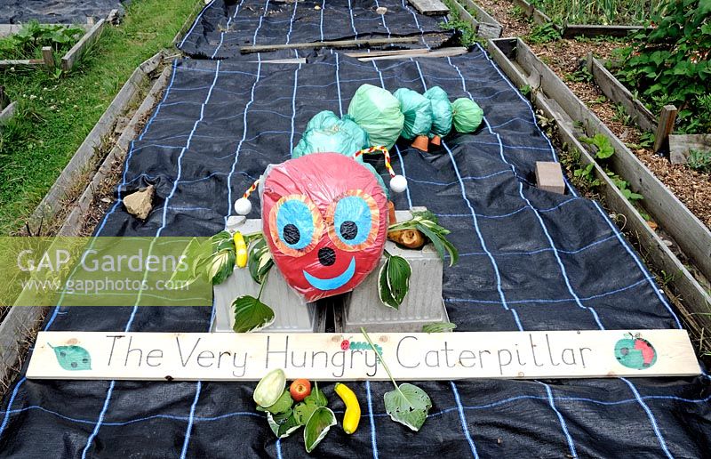 The Very Hungry Caterpillar model surrounded by fruit and vegetables, Paddock Allotments 