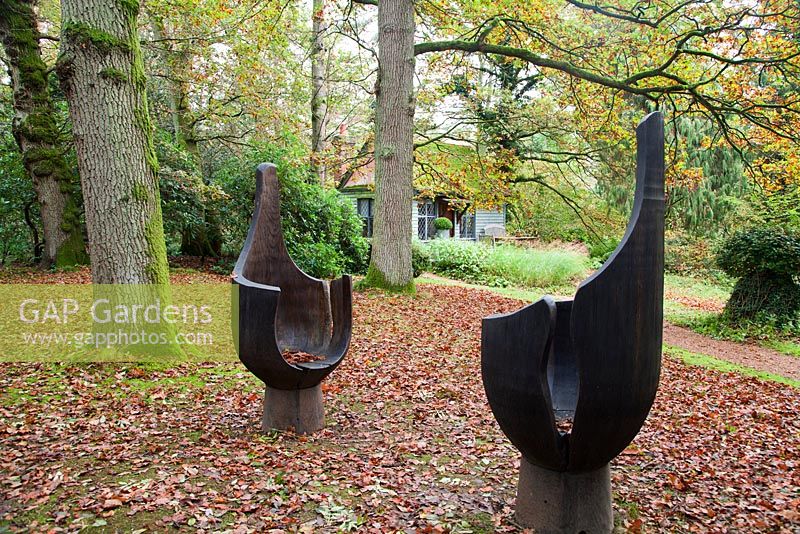 Chair Forms 1 and 2 in foreground by Liam O'Neill made from Irish oak. The Hannah Peschar Sculpture Garden, Surrey