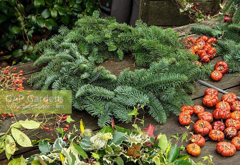 Christmas wreath made using a 40cm wire wreath frame, sphagnum moss, spruce, dried pumpkins, rose hips and ribbon. 