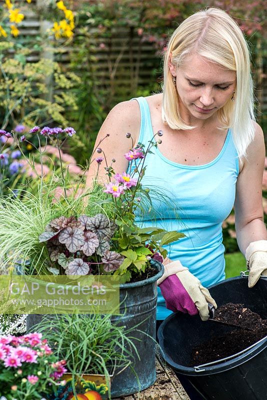 Planting a salvaged pot step by step. Top up the container with potting compost and firm down to secure plants.