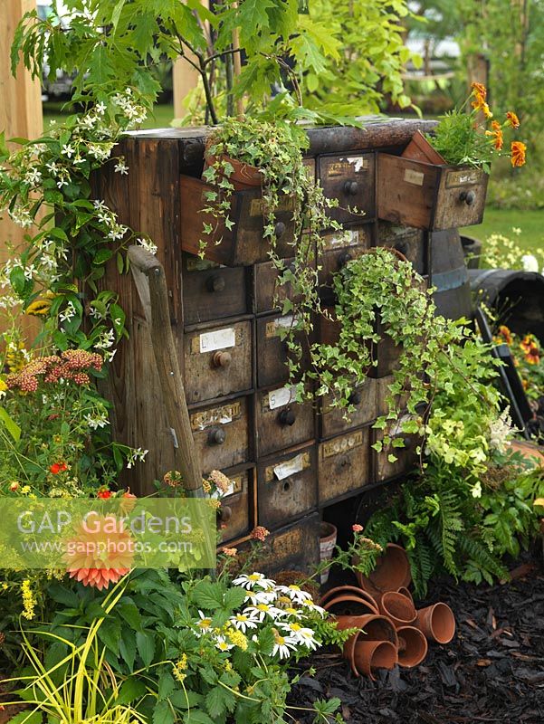 An old chest of drawers finds a new lease of life in the corner of a family garden.