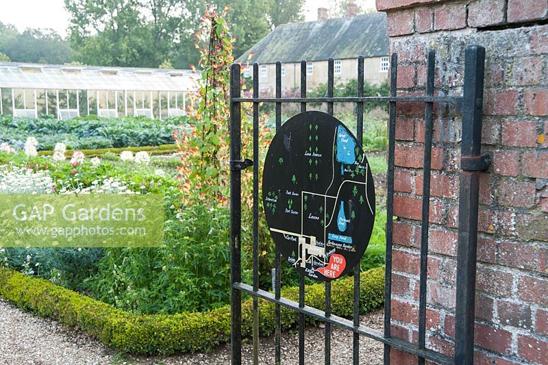 Simple graphic map of the garden painted on a metal roundel, mounted on the gate into the kitchen garden. Forde Abbey, nr Chard, Dorset, UK