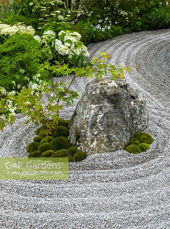 A small Japanese style garden with island bed and raked gravel which symbolises water.