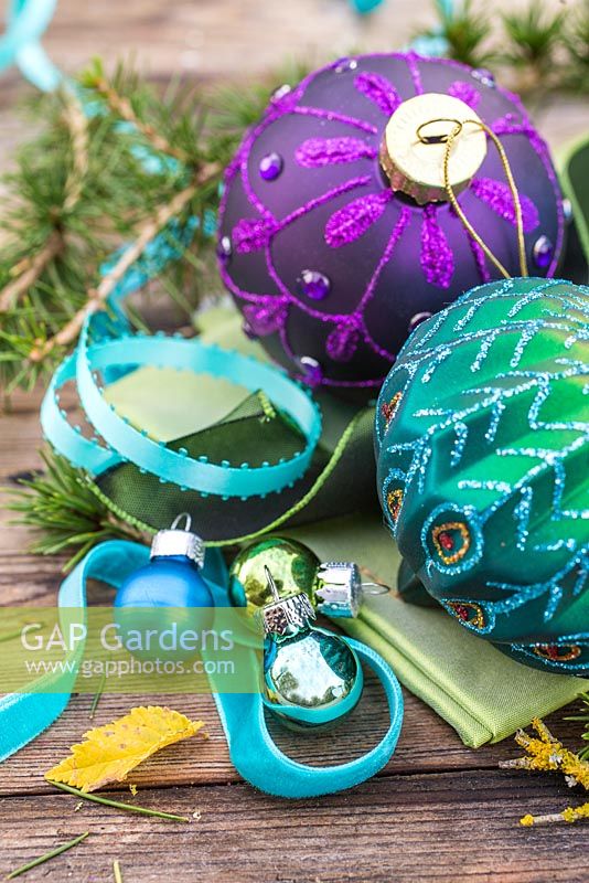Peacock colour themed Christmas decorations. Baubles, ribbon and larch foliage