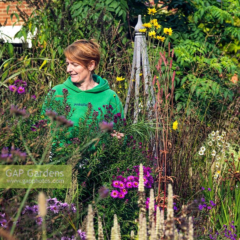 Anne Godfrey amongst the tall perennials in her garden.