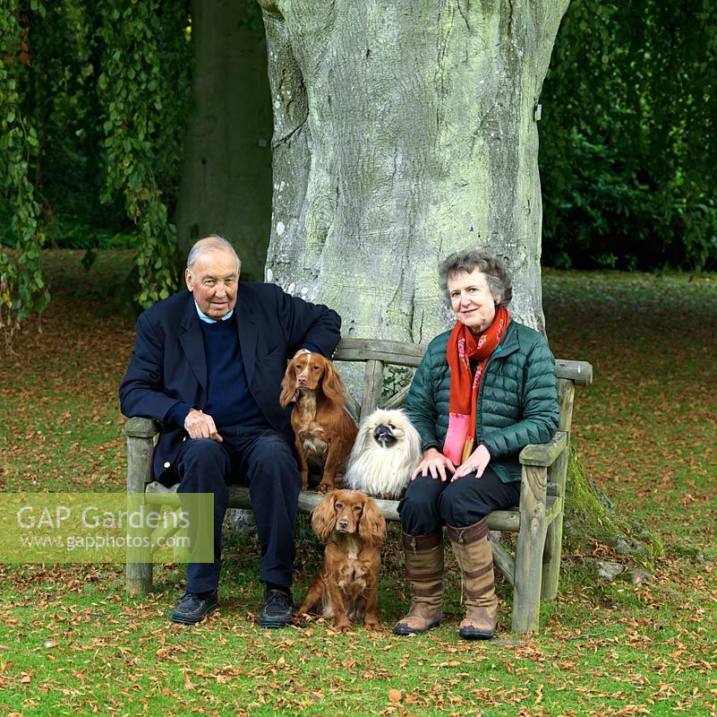 Lawrence and Elizabeth Banks with their three dogs, on a bench beneath a huge old beech tree planted a century ago.