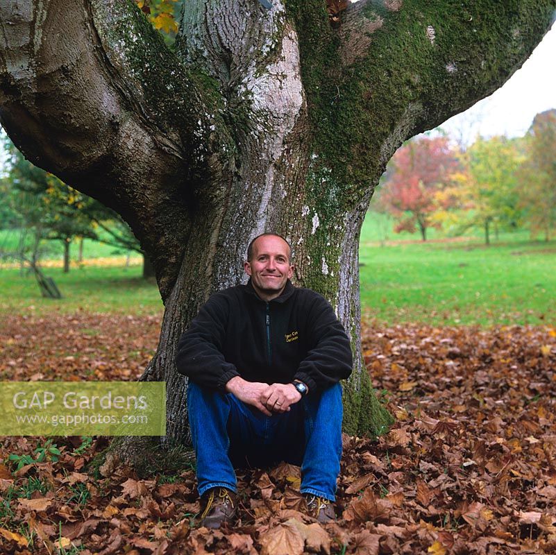 Stephen Lloyd, head gardener, having worked at Hergest Croft since 1984. Resting against trunk of old Acer platanoides 'Schwedleri'