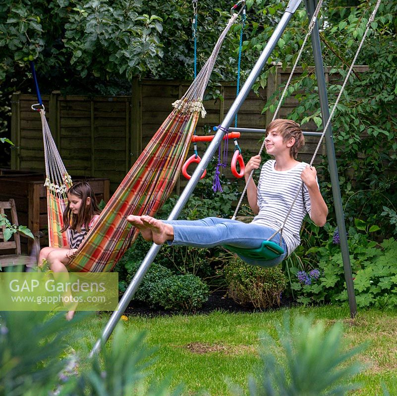 Lily, 10, lazes in the hammock whilst her sister, Scarlett, 13, swings.