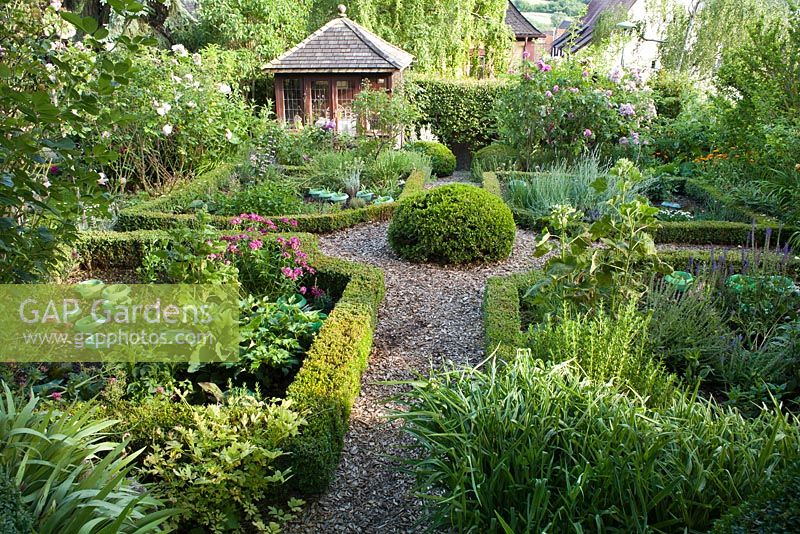 Knot garden with box hedging and topiary. Pathway to the summerhouse. Marina Wust, Germany