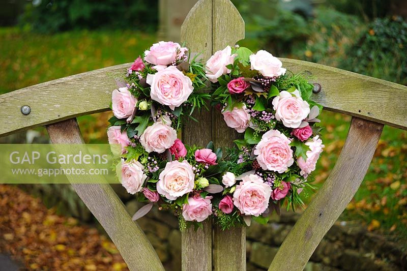 Pink roses in a two part circular arrangement on church lych gate for a wedding. Rose 'Keira' a cut flower variety from David Austin Roses