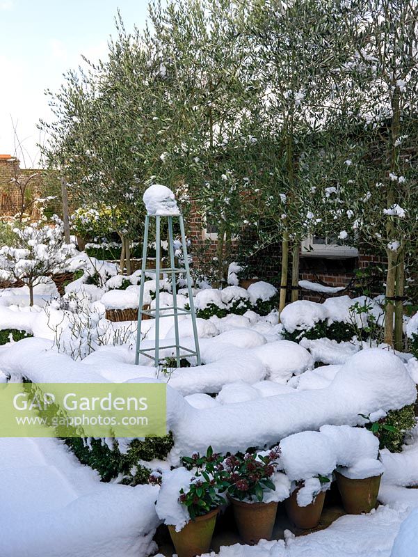 Snow covered small walled formal garden