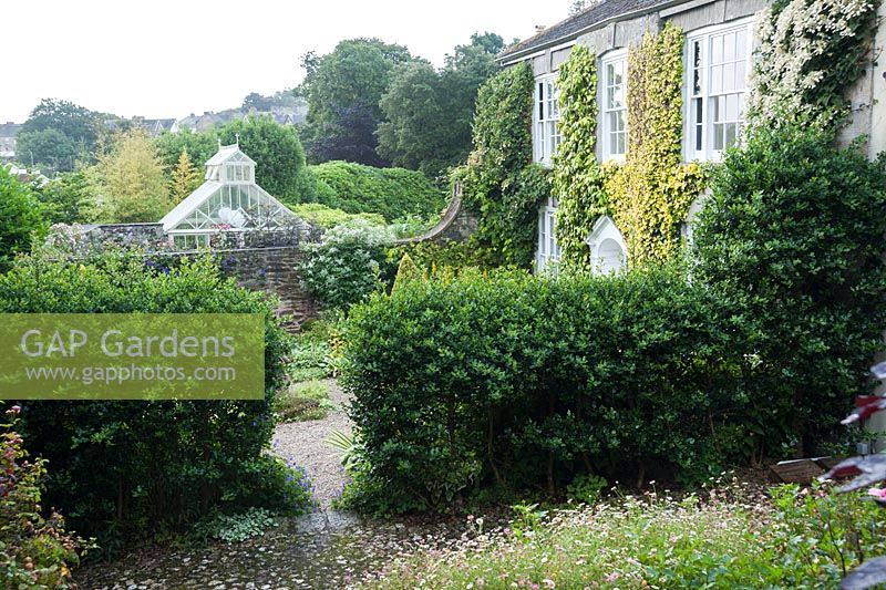 View across the Vean Garden to the conservatory and Truro beyond. Bosvigo, Truro, Cornwall, UK