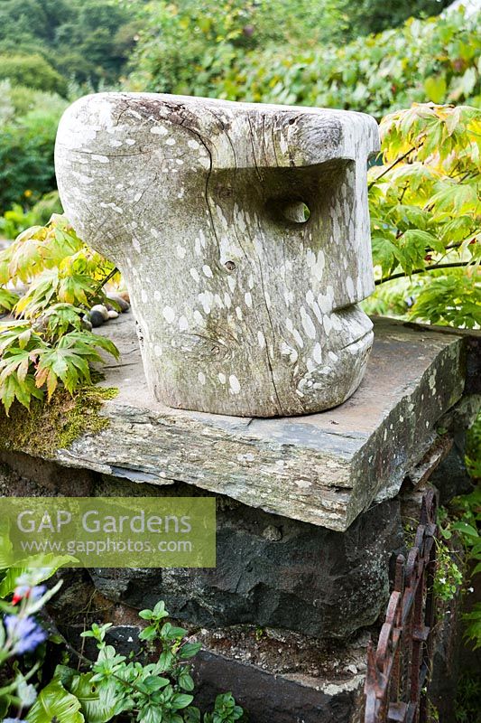 Chunky wooden head sits on the wall around the front garden surrounded 