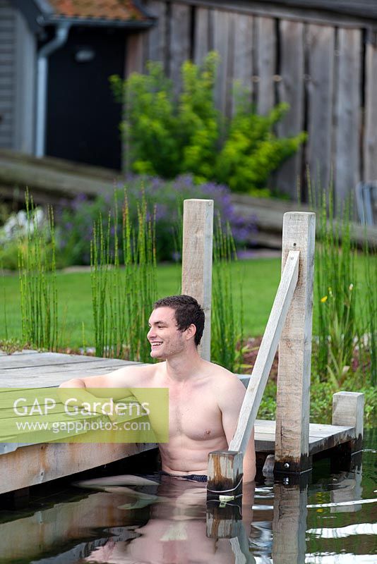 Man relaxing in swimming pond.