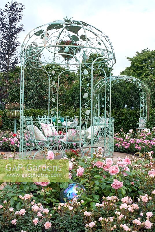 Metal ornate arbour with table and chairs in a Rose Garden - The Croft Spot Passion Garden, RHS Hampton Court Palace Flower Show 2007
