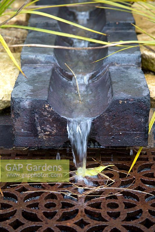 Rustic stone water feature with metal grill