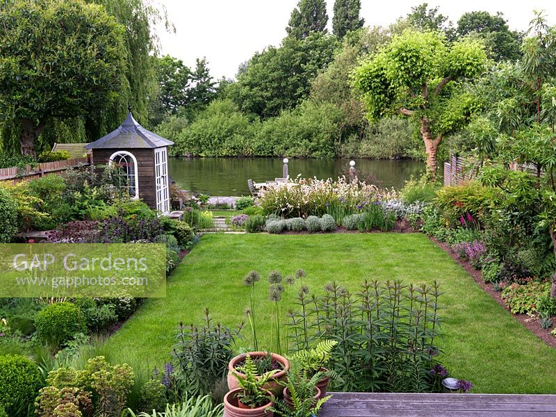 Riverside garden by Andy Sturgeon. Left bed - oak cubes, allium, erysimum, Hebe vernicosa, box, iris, aquilegia, fern, nandina, mahonia. Far - libertia, iris, euphorbia, santolina.