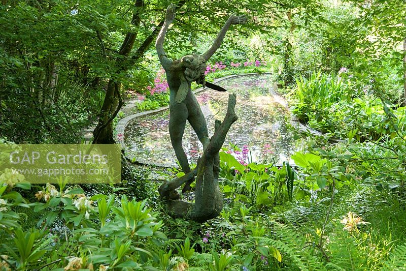 Oberon and Titania sited near the pond in the woodland garden. King John's Nursery, Etchingham, East Sussex, UK