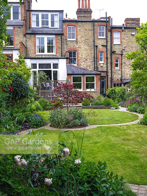Circular lawns and a circular island bed provide the theme in a modern town garden.
