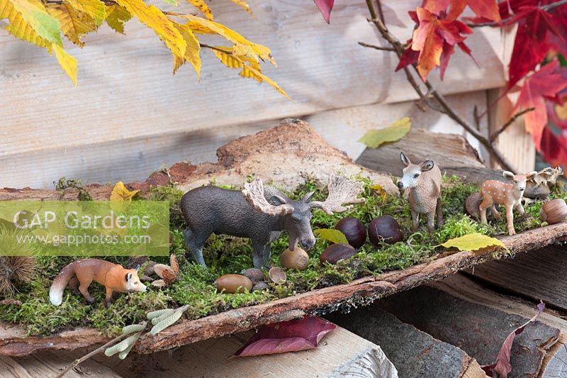 Forest themed table decoration with animal figures - elk, deer and fox - on moss