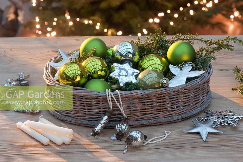 Green and silver Christmas tree decorations - balls, silver stars, angels, snow crystals, candle holders and candles with basket