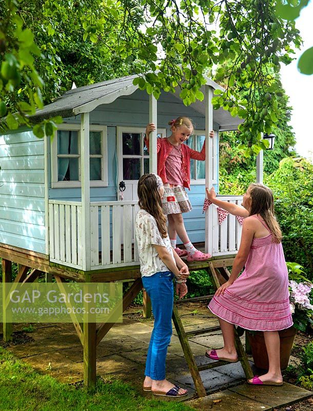 Scarlet 12, Olivia 7 and Maja 13 playing in the raised children's summerhouse.
