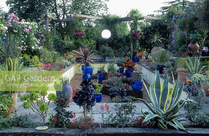 Sunken garden with drought tolerant plants and sun mirror focal point, June