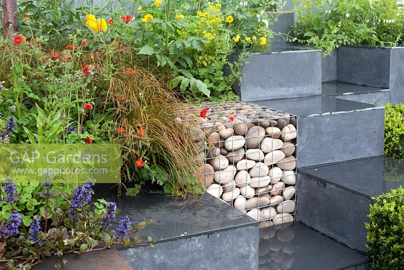 Ooooh ...it makes me wonder. Malvern Spring Gardening Show 2014, inspired by the classic Led Zeppelin song 'Stairway to Heaven', and the Giant's Causeway rock formation, with cubes of geum, and buxus and gabions - Designer: Teresa Rham - Sponsor: The Dingle Nurseries and Gardens