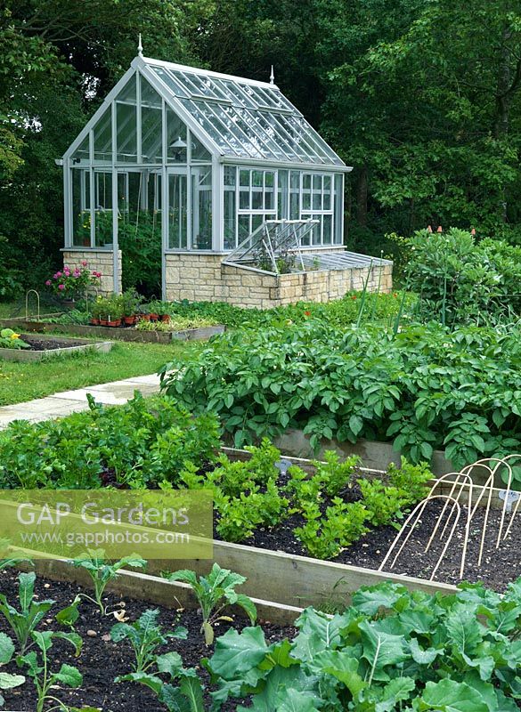 Raised beds and greenhouse in a productive country vegetable garden.