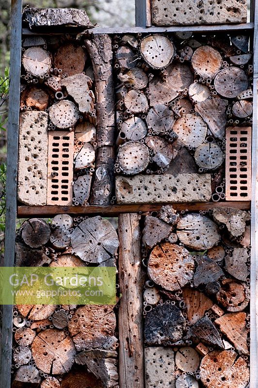 Nesting opportunities for wild bees, an insect hotel made from logs with holes drilled into them