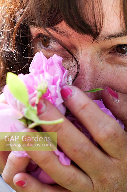 Woman smells rose flowers