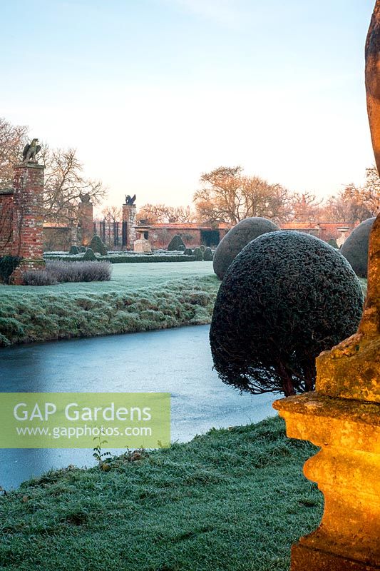 Moat and topiary with frost at Helmingham Hall, Suffolk