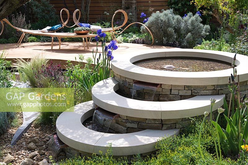 Royal Bank of Canada Garden. Three tiered circular pool, sculptural seats by Tom Raffield on curved decking, Iris 'Mer du Sud' 