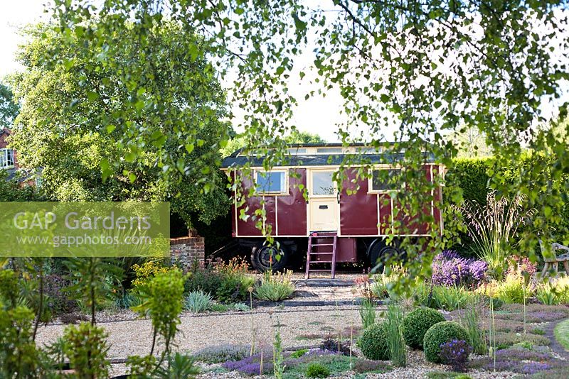 A gravel garden with caravan, an unusual summerhouse