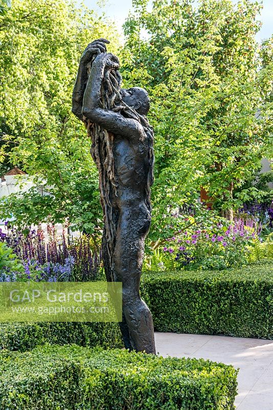 The Morgan Stanley Healthy Cities Garden. Bronze sculpture of a figure with box hedging and herbaceous borders in background