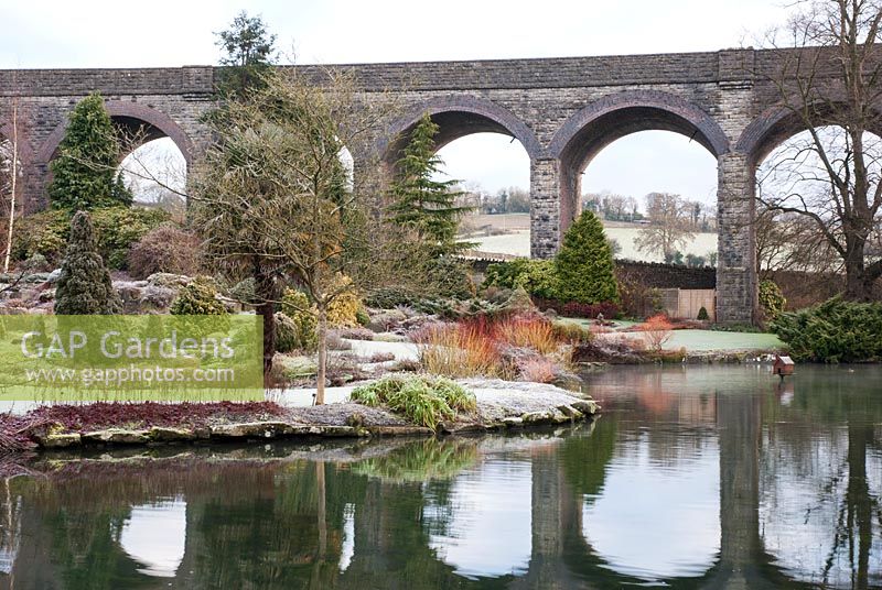 View across the lake with viaduct and reflection in water - Kilver Court, Somerset