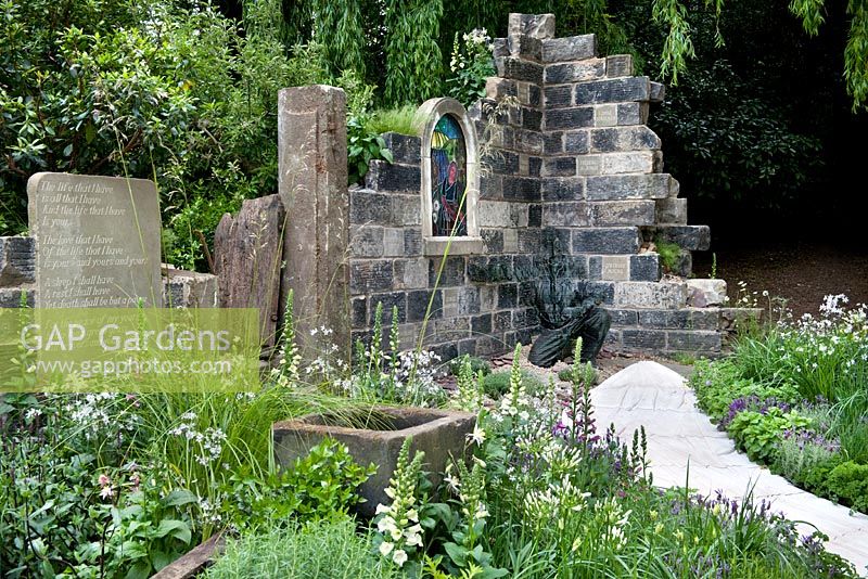 Stone walled church ruin, pathway, water trough and cottage garden plants including Digitalis purpurea - foxglove and herbs. The Evaders Garden by Chorley Council. RHS Chelsea Flower Show, 2015